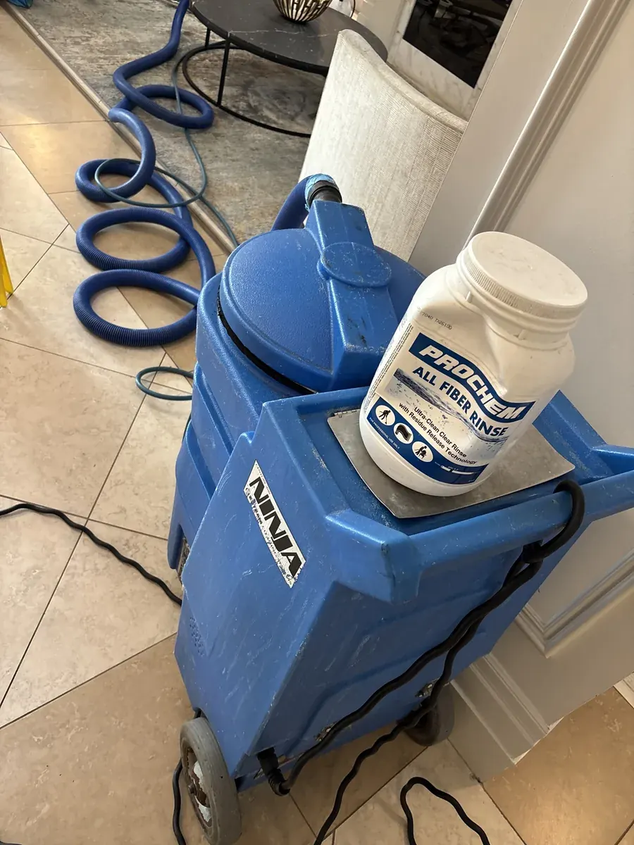 Prochem All Fiber Rinse container sitting on a blue Ninja portable carpet extractor in a hallway