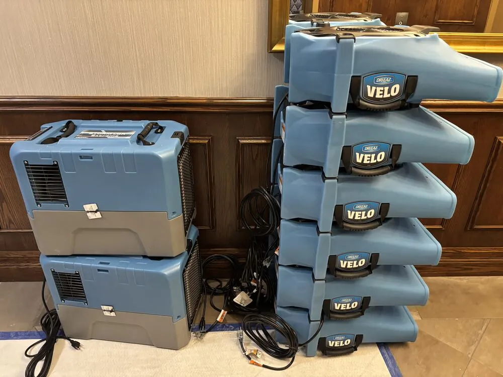 Commercial air movers and a dehumidifier staged on site for structural drying after water damage